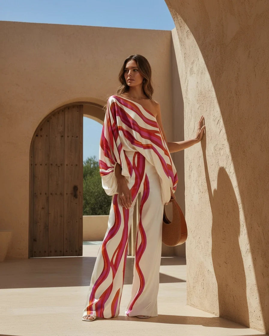 Model wearing an abstract print one-shoulder top with matching wide-leg trousers. - 6