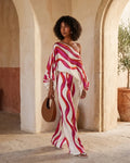 Model wearing an abstract print one-shoulder top with matching wide-leg trousers.