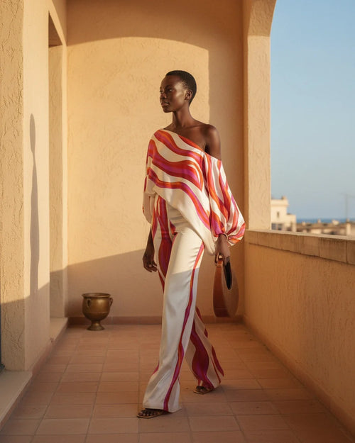Model wearing an abstract print one-shoulder top with matching wide-leg trousers. - 2