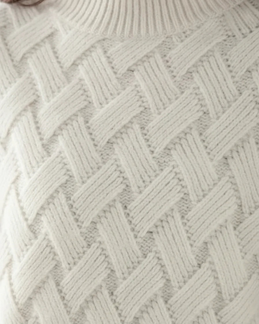 Woman wearing a beige relaxed-fit turtleneck sweater with a textured basketweave knit pattern. - 6