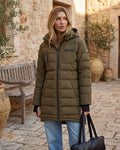 Mid-length olive green quilted puffer coat with a hood and black zipper details on a model.