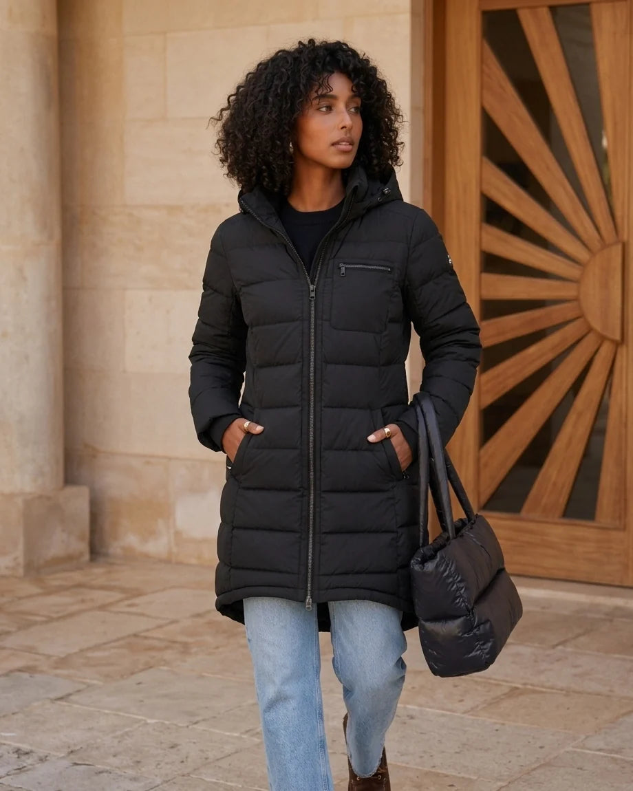Mid-length olive green quilted puffer coat with a hood and black zipper details on a model. - Black variant