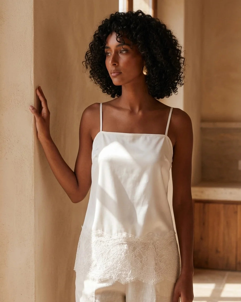 Cream satin camisole with spaghetti straps and eyelash lace trim hem.
