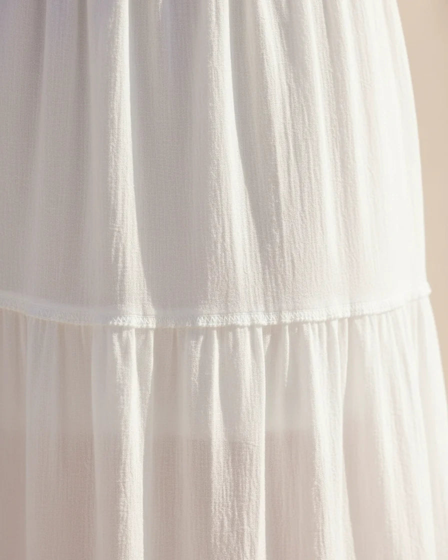 A flowing off-the-shoulder maxi dress in white with lace-trimmed bell sleeves and a tiered skirt. - 6