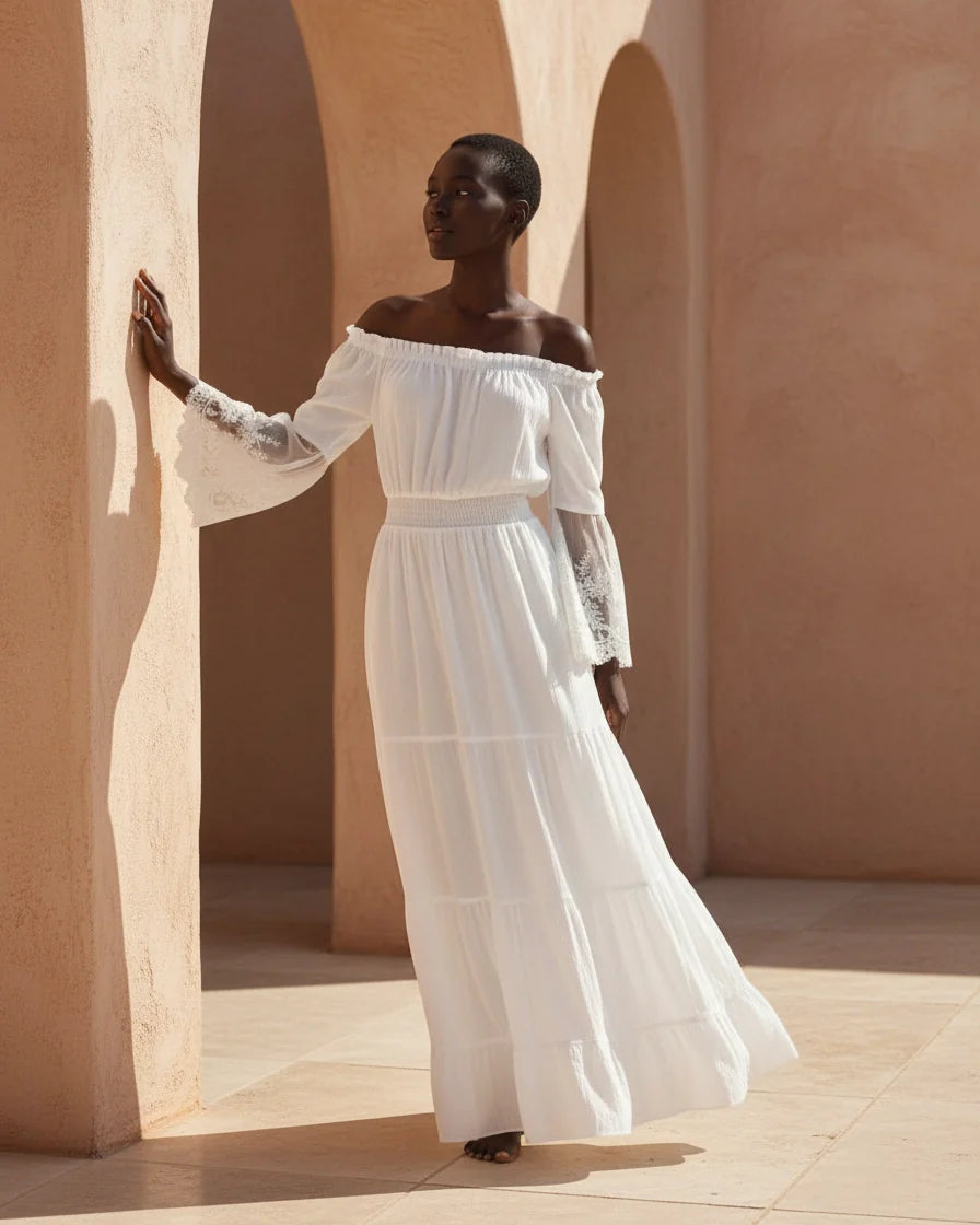 A flowing off-the-shoulder maxi dress in white with lace-trimmed bell sleeves and a tiered skirt. - 2