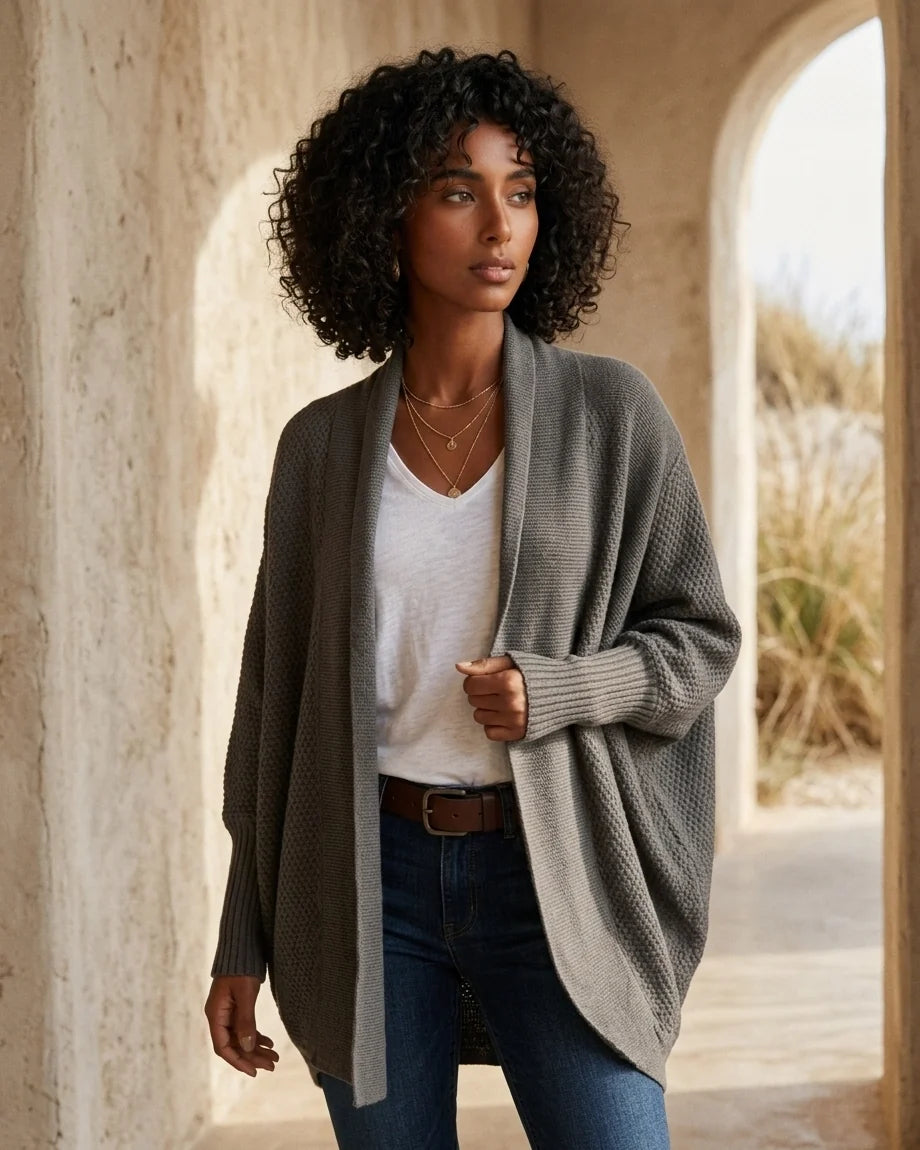 Oversized knit cardigan in army green featuring dramatic batwing sleeves and long ribbed cuffs.