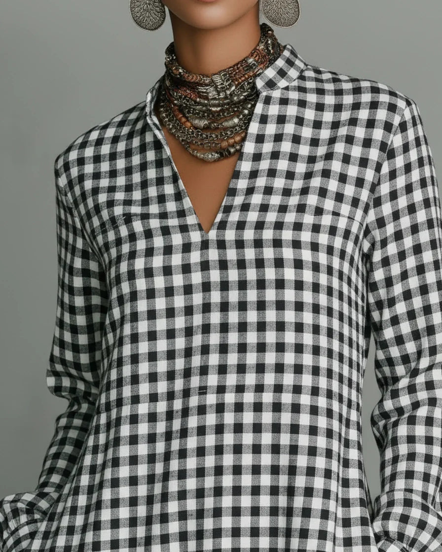 Front view of a woman wearing a black and white gingham plaid maxi dress with long sleeves and a split V-neckline. - 3