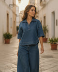 Woman wearing a short-sleeve collared denim top with wide-leg trousers in a matching colorway