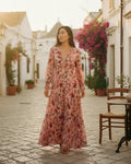 Woman wearing a floral-print maxi dress with a V-neckline and long cuffed sleeves - Pink