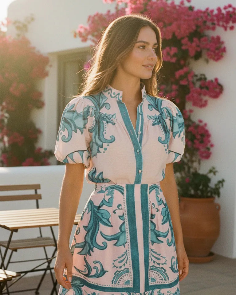 Woman wearing a printed two-piece set with a buttoned puff-sleeve top and a short pleated skirt - Cyan