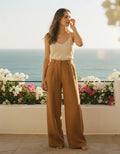 Woman wearing linen wide-leg trousers with a relaxed high-rise fit and flowing leg