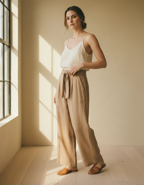 Woman wearing high-rise wide-leg oat linen trousers
