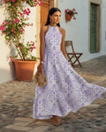 Woman wearing a printed halter-neck maxi dress with an easy A-line drape - Pink