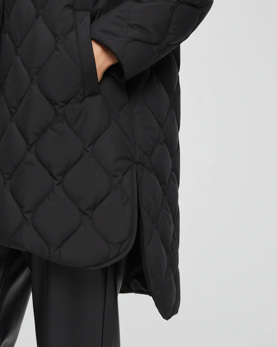 Black diamond quilted puffer jacket with a high stand collar and snap closures on a model. - 7