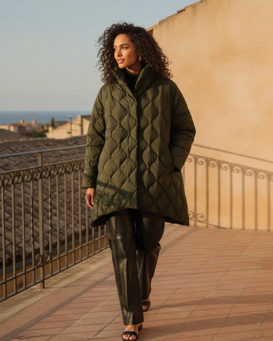 Black diamond quilted puffer jacket with a high stand collar and snap closures on a model. - 4