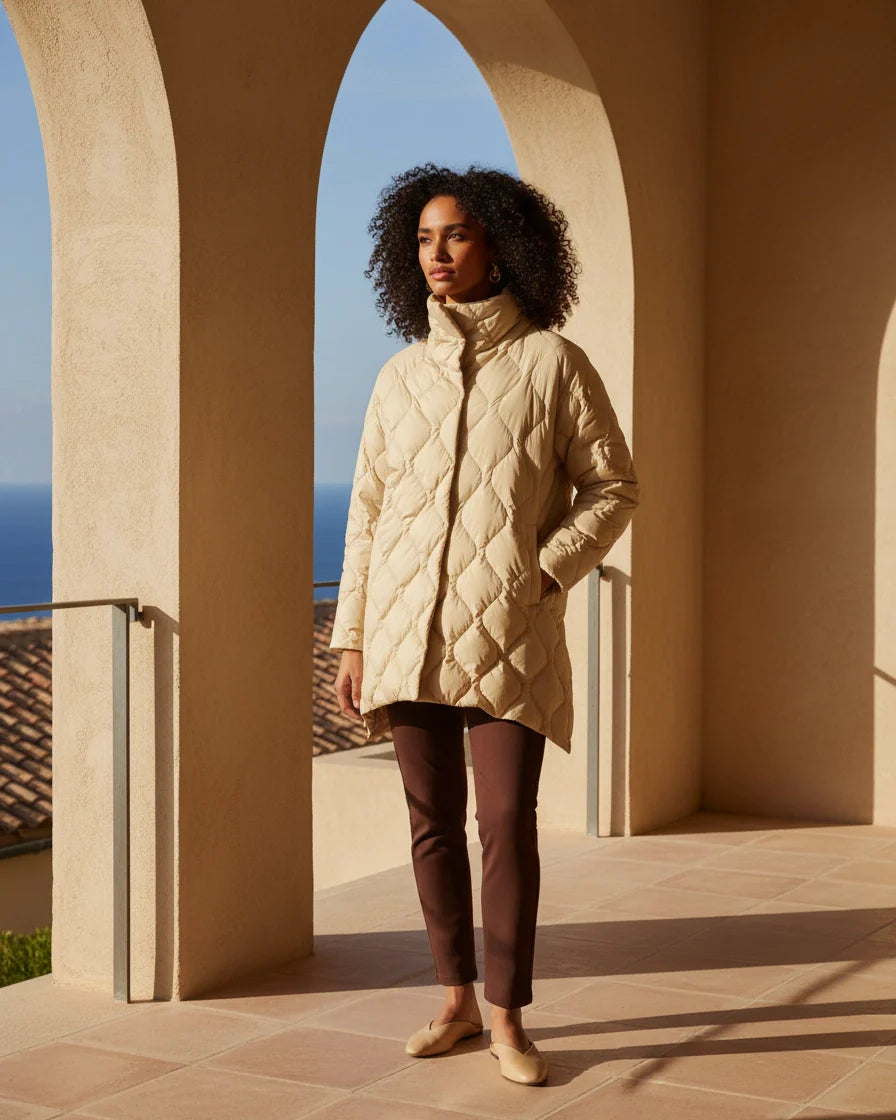 Black diamond quilted puffer jacket with a high stand collar and snap closures on a model. - 5