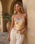 Cropped rose gold camisole featuring large circular sequins on a mesh backing with adjustable straps.